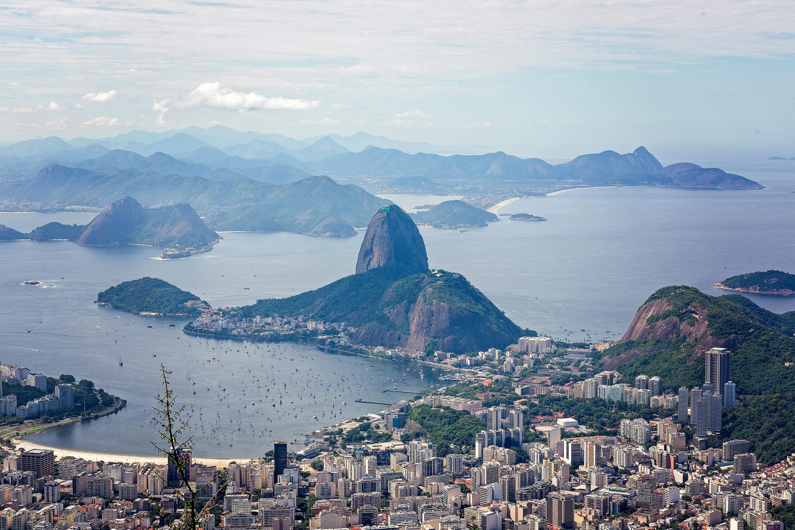 A breathtaking aerial view of Rio de Janeiro featuring Sugarloaf Mountain and Guanabara Bay.