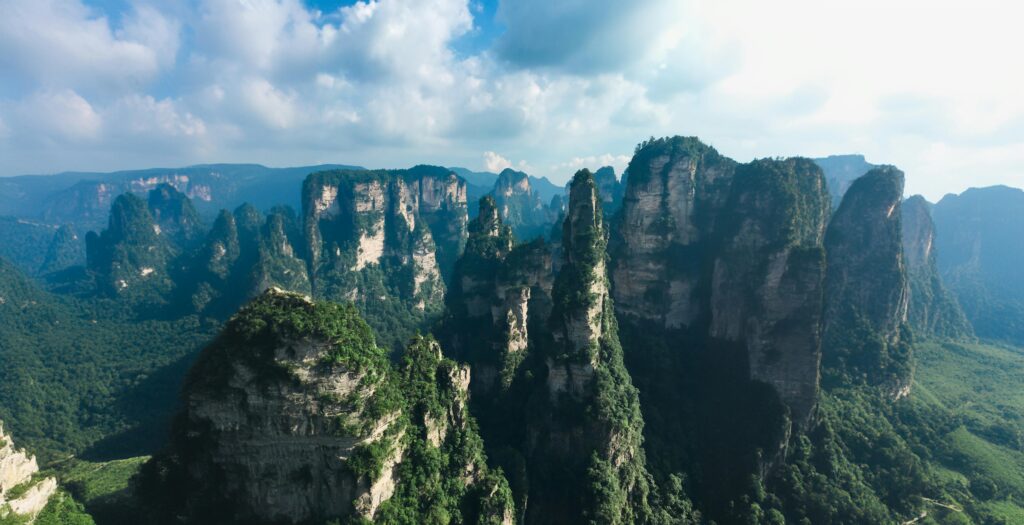 Explore Zhangjiajie's iconic pillar-like mountains under a stunning sky, a must-see for nature lovers.